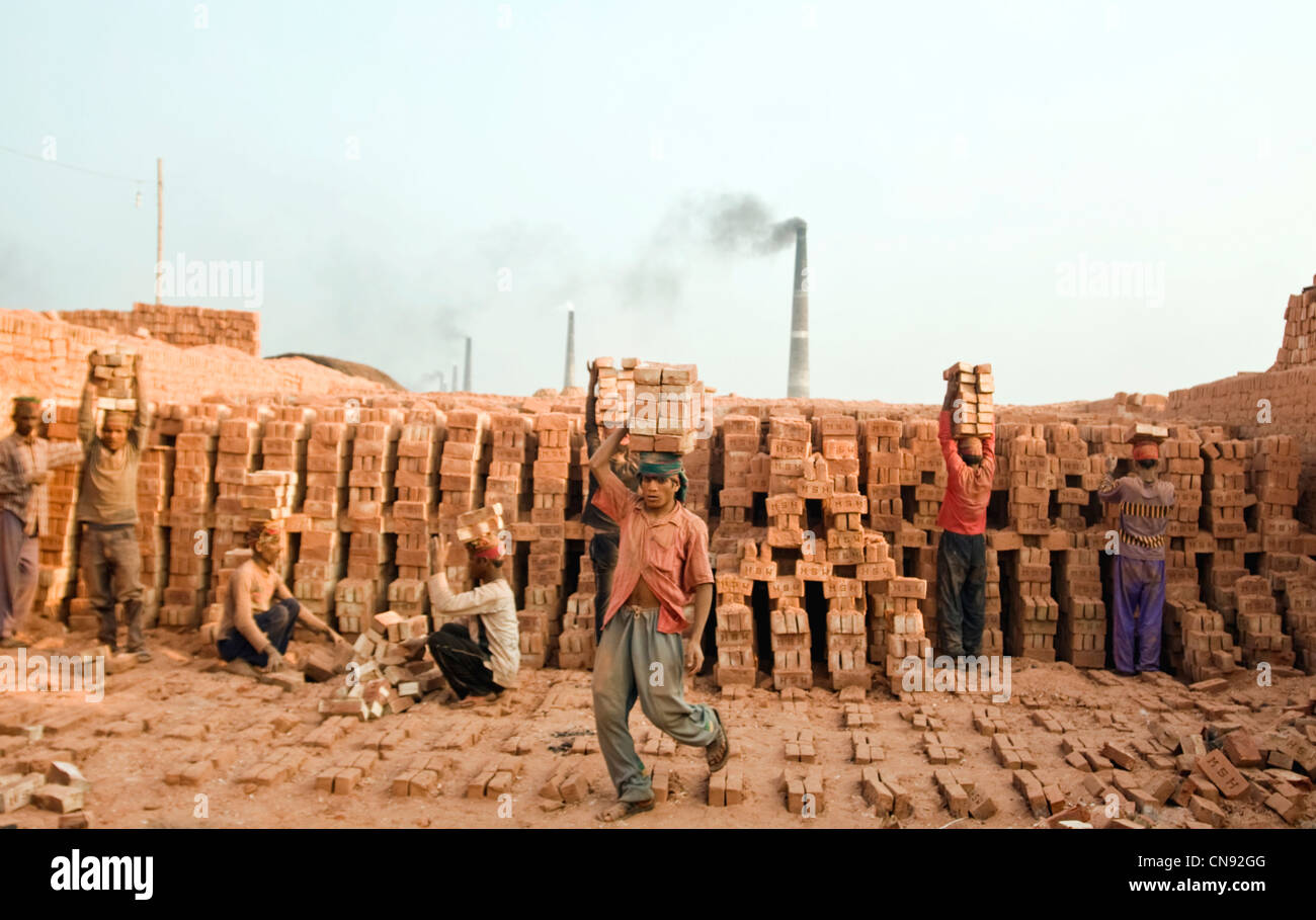 Gli uomini che trasportano in mattoni a Fatullah fabbrica di mattoni vicino Dakha , Bangladesh. Foto Stock