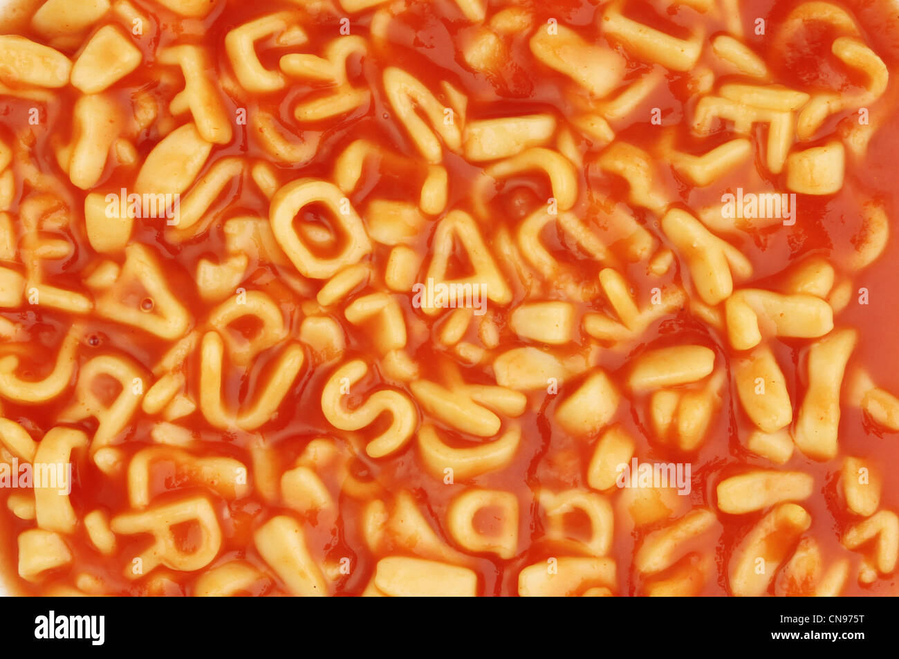 Alfabeto spaghetti al sugo di pomodoro come sfondo e texture Foto Stock