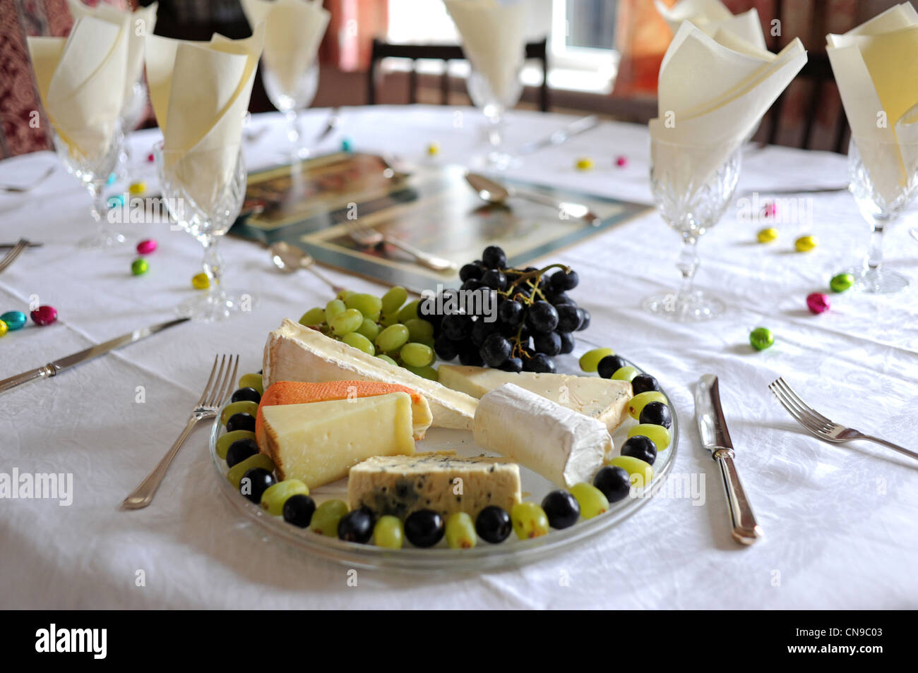 Altopiano di formaggio o la piastra ad un tavolo per la cena con uve posizionati intorno al bordo Foto Stock