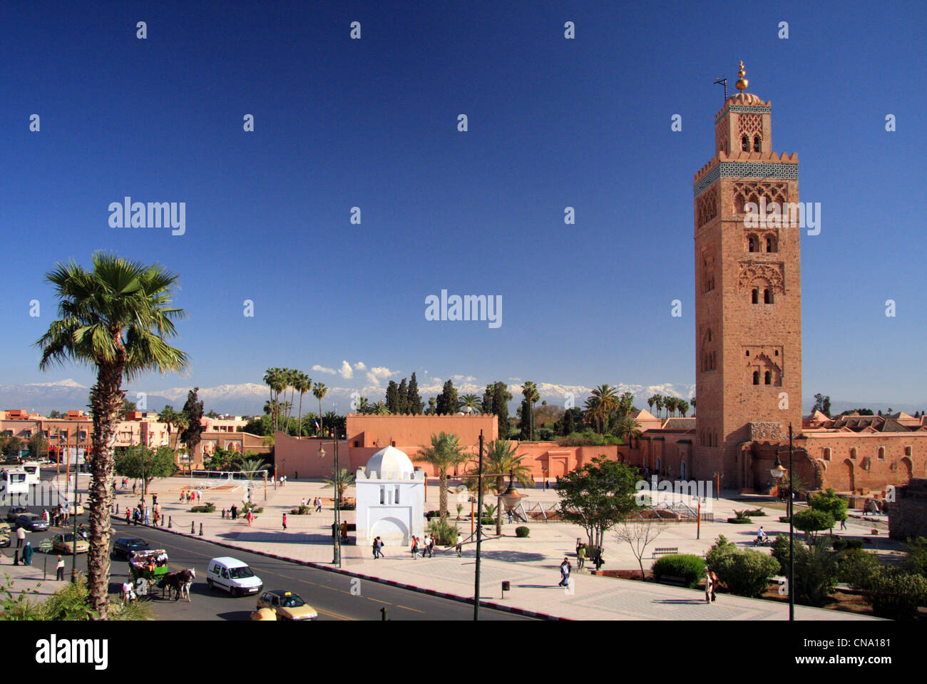 Il minareto della moschea Koutoubia si eleva sopra Avenue Mohammed V contro la neve cappuccio Alto Atlante, Marrakech, Marocco, Africa Foto Stock