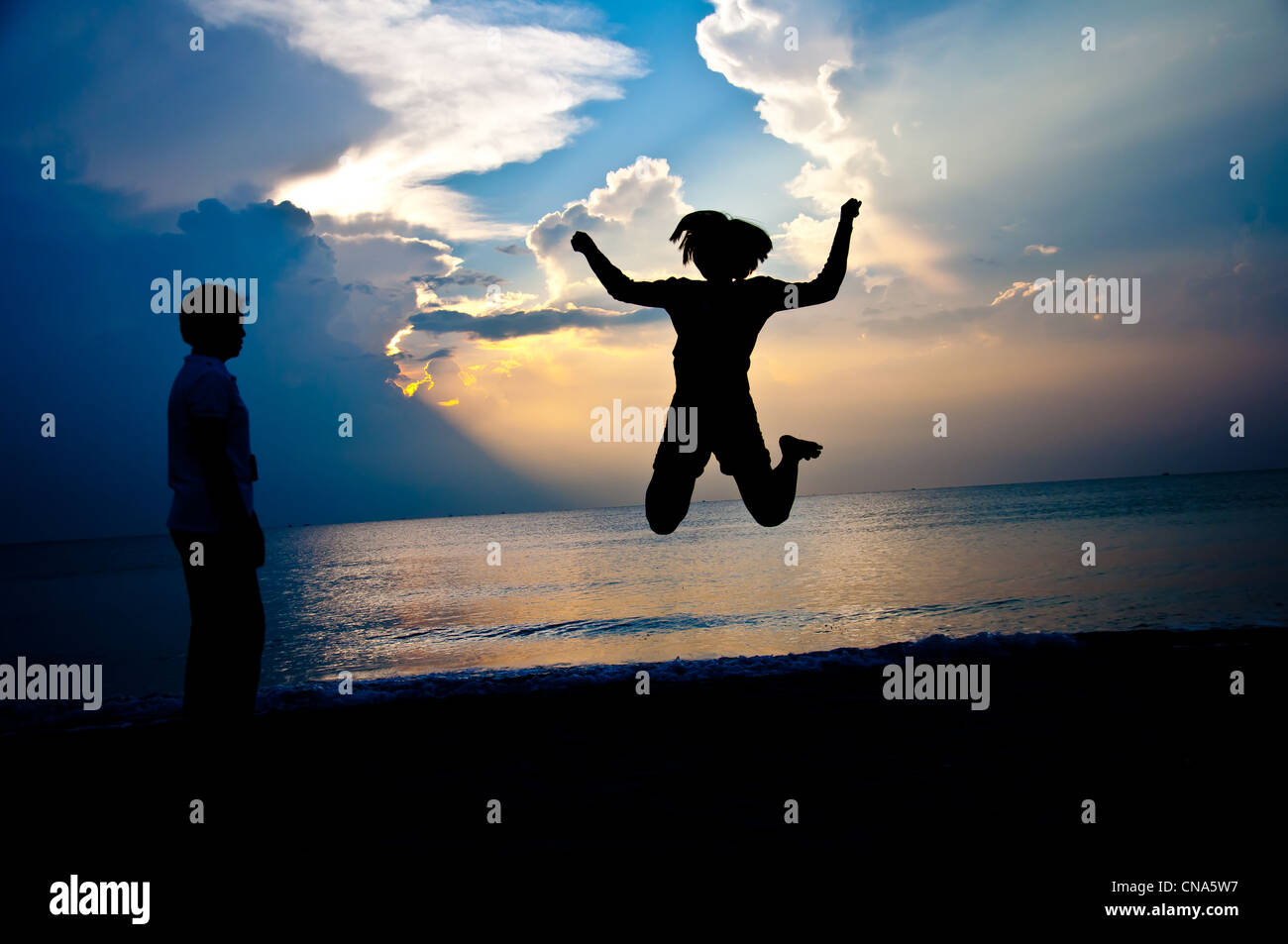 Silhouette della figlia e madre felice sulla spiaggia Foto Stock