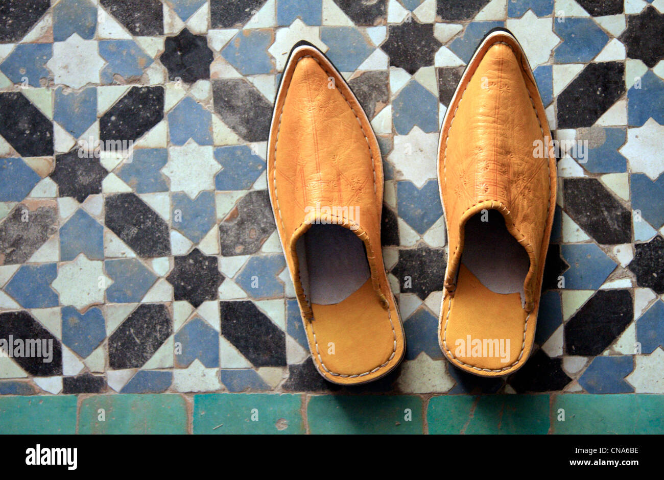 Una coppia di Marocchino tradizionale pantofola-scarpe (babouches) contro il mosaico tradizionale tilework (zellij) in Marrakech, Marocco Foto Stock