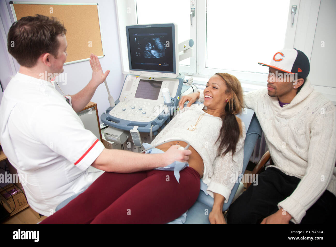 Una giovane donna incinta subisce una scansione ad ultrasuoni REGNO UNITO Foto Stock