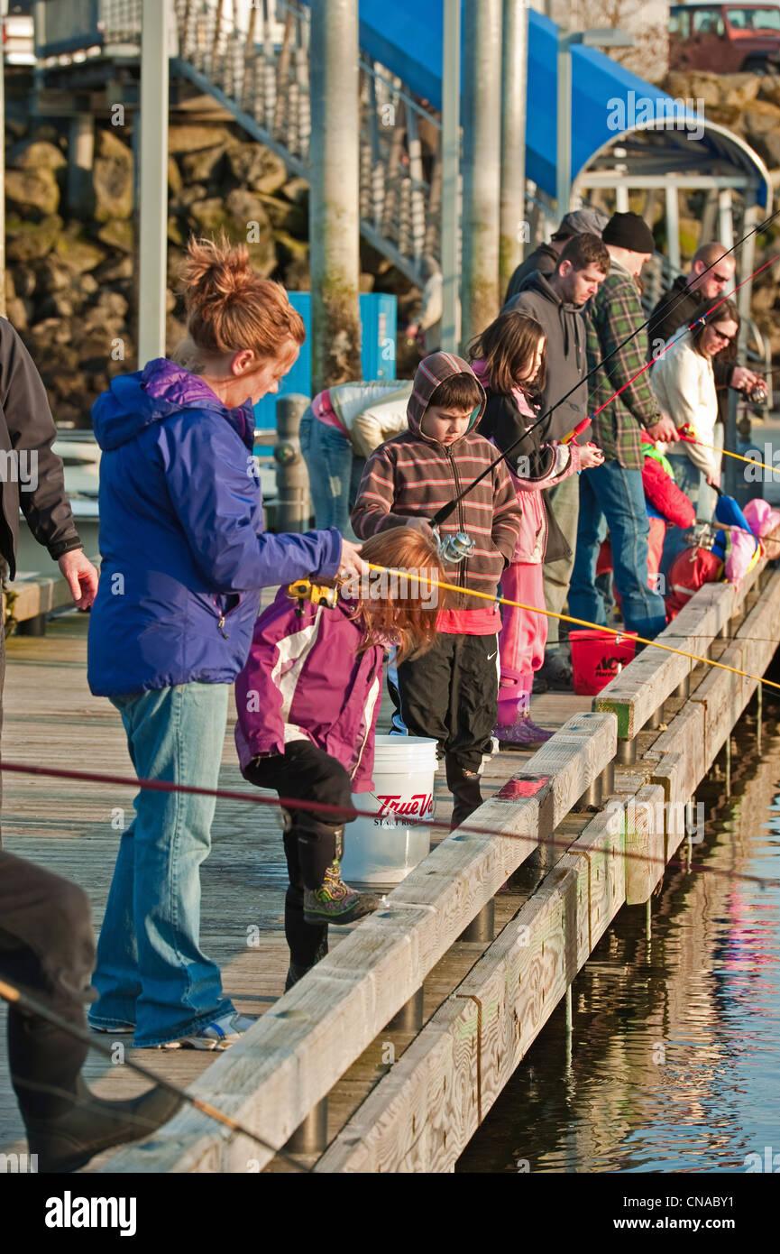 Famiglie la pesca di aringa del Pacifico dal dock a Thomsen Porto di Sitka, Alaska. Foto Stock