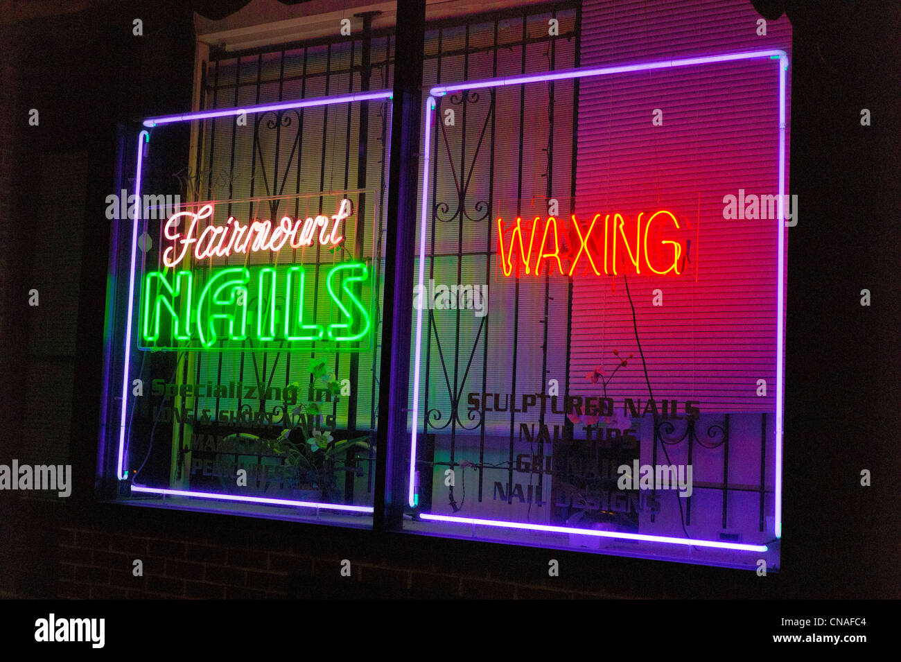 Insegne al neon illuminata di notte nella finestra di unghie & shop di ceratura, Philadelphia, Pennsylvania, STATI UNITI D'AMERICA Foto Stock
