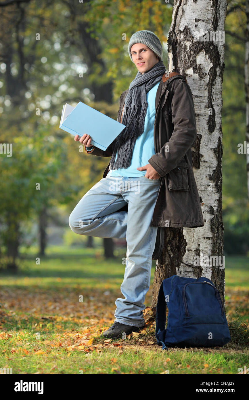 Giovane uomo leggendo un libro nel parco della città Foto Stock