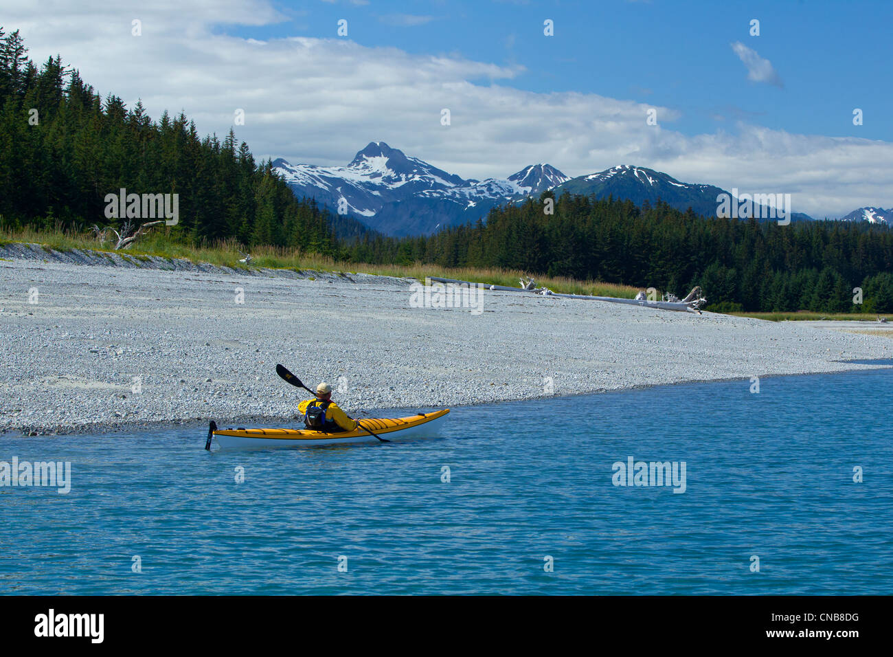 Sea kayaker pale lungo il litorale vicino a Juneau con Chilkat montagne sullo sfondo, Lynn Canal, a sud-est di Alaska Foto Stock