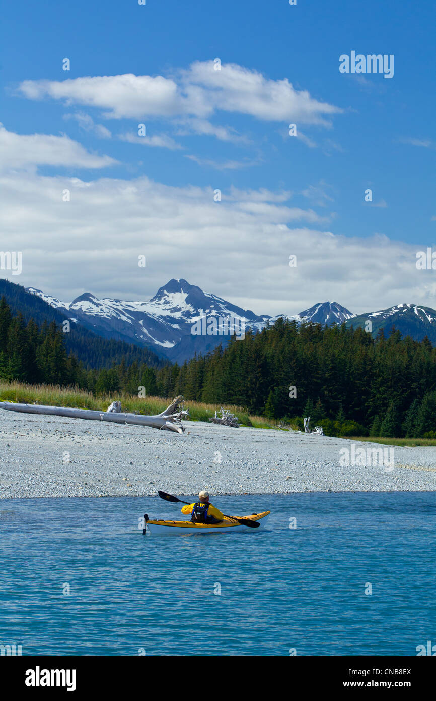 Sea kayaker pale lungo il litorale vicino a Juneau con Chilkat montagne sullo sfondo, Lynn Canal, a sud-est di Alaska Foto Stock
