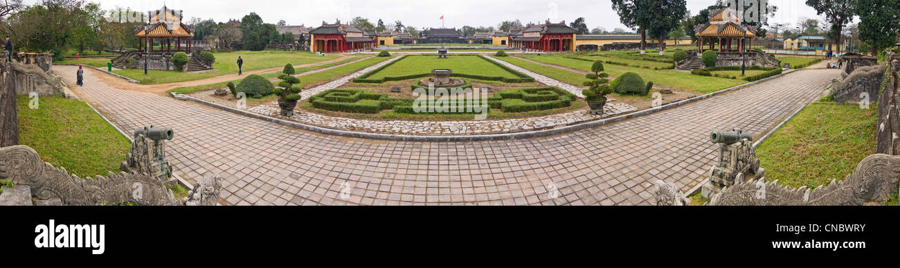Panoramica orizzontale vista dei giardini presso la cittadella imperiale con Thai Hoa Palace e la torre di bandiera in background in tinta. Foto Stock