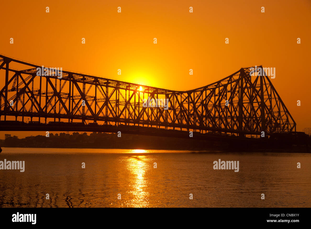 India Bengala Occidentale, Kolkata (Calcutta), tramonto dietro quella di Howrah ponte di sospensione Foto Stock