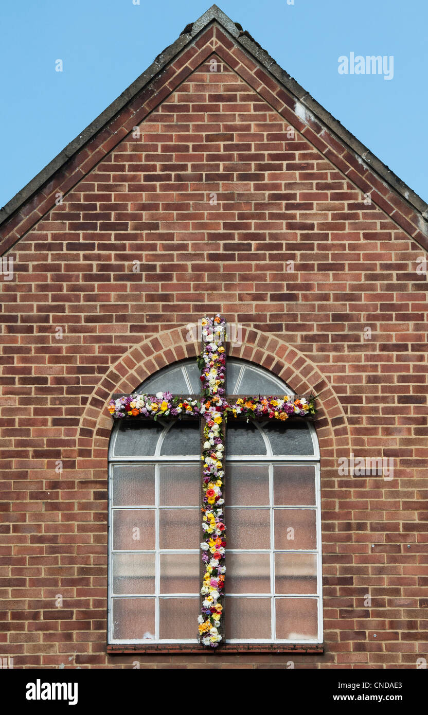 Croce di Pasqua e fiori su una chiesa cristiana evangelica. Banbury, Oxfordshire, Inghilterra Foto Stock