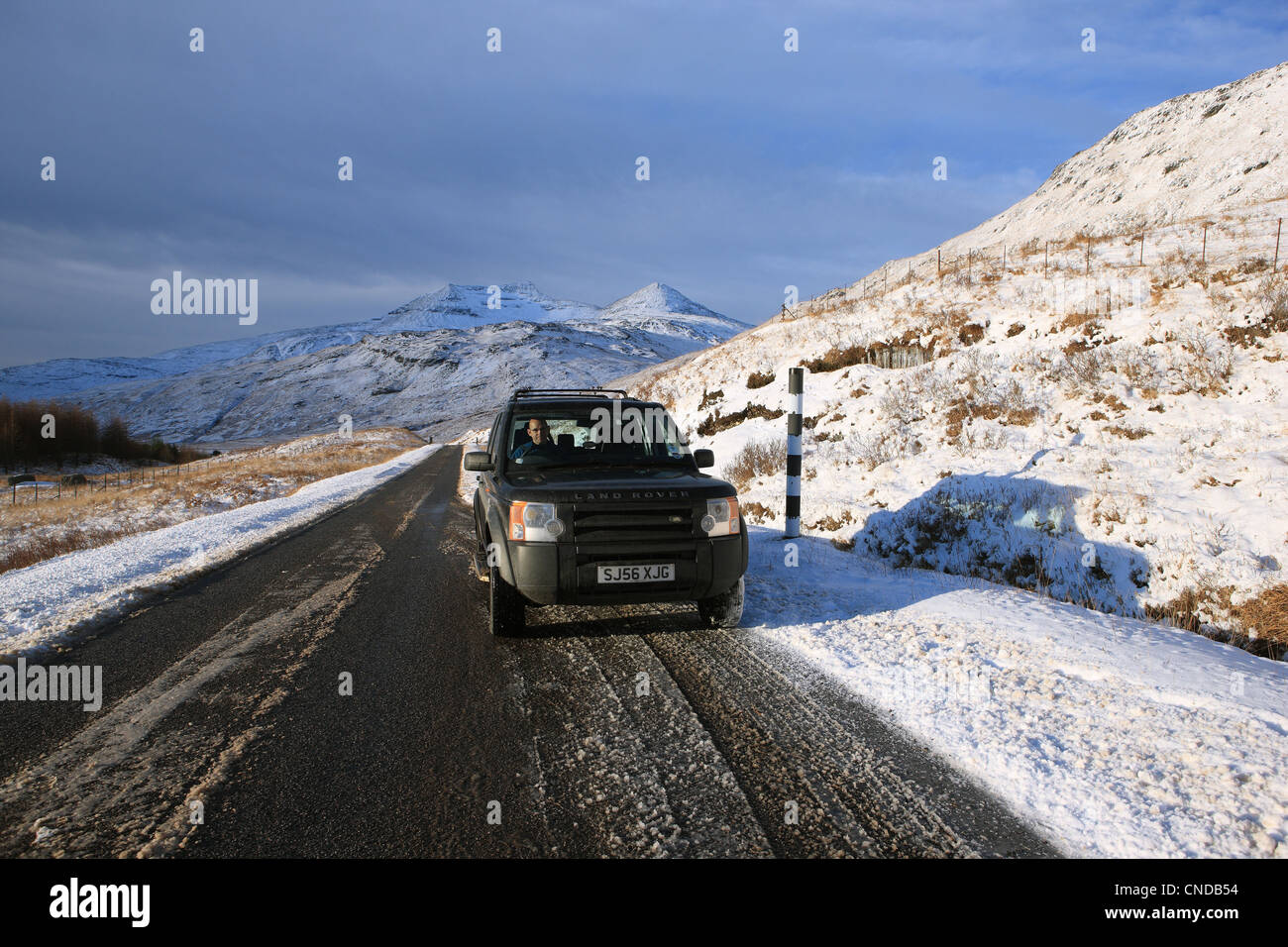 Land Rover su una strada ghiacciata in Scozia Foto Stock