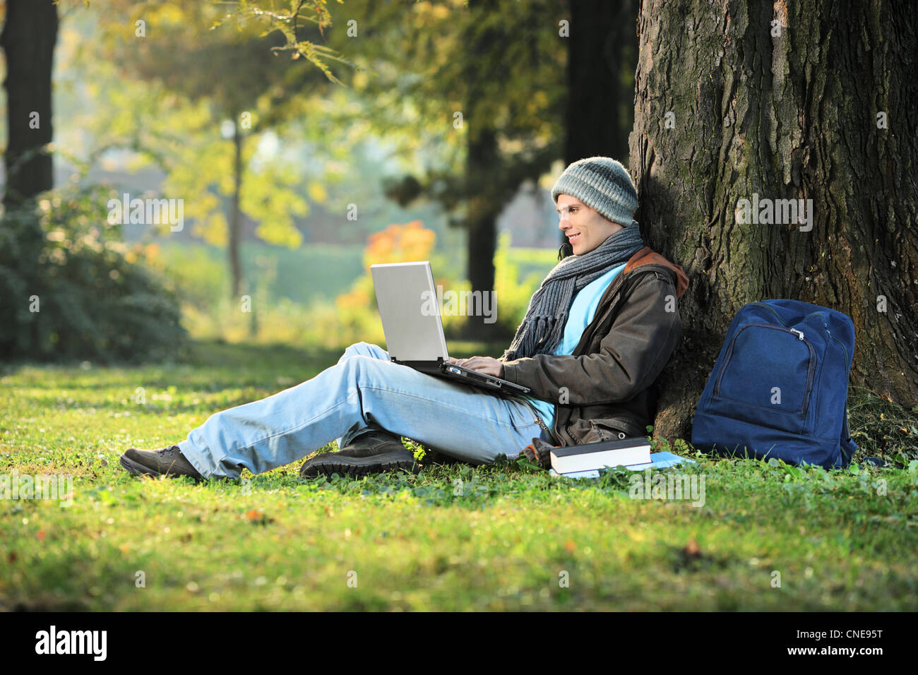 Uomo al lavoro su un computer portatile nel parco della città Foto Stock