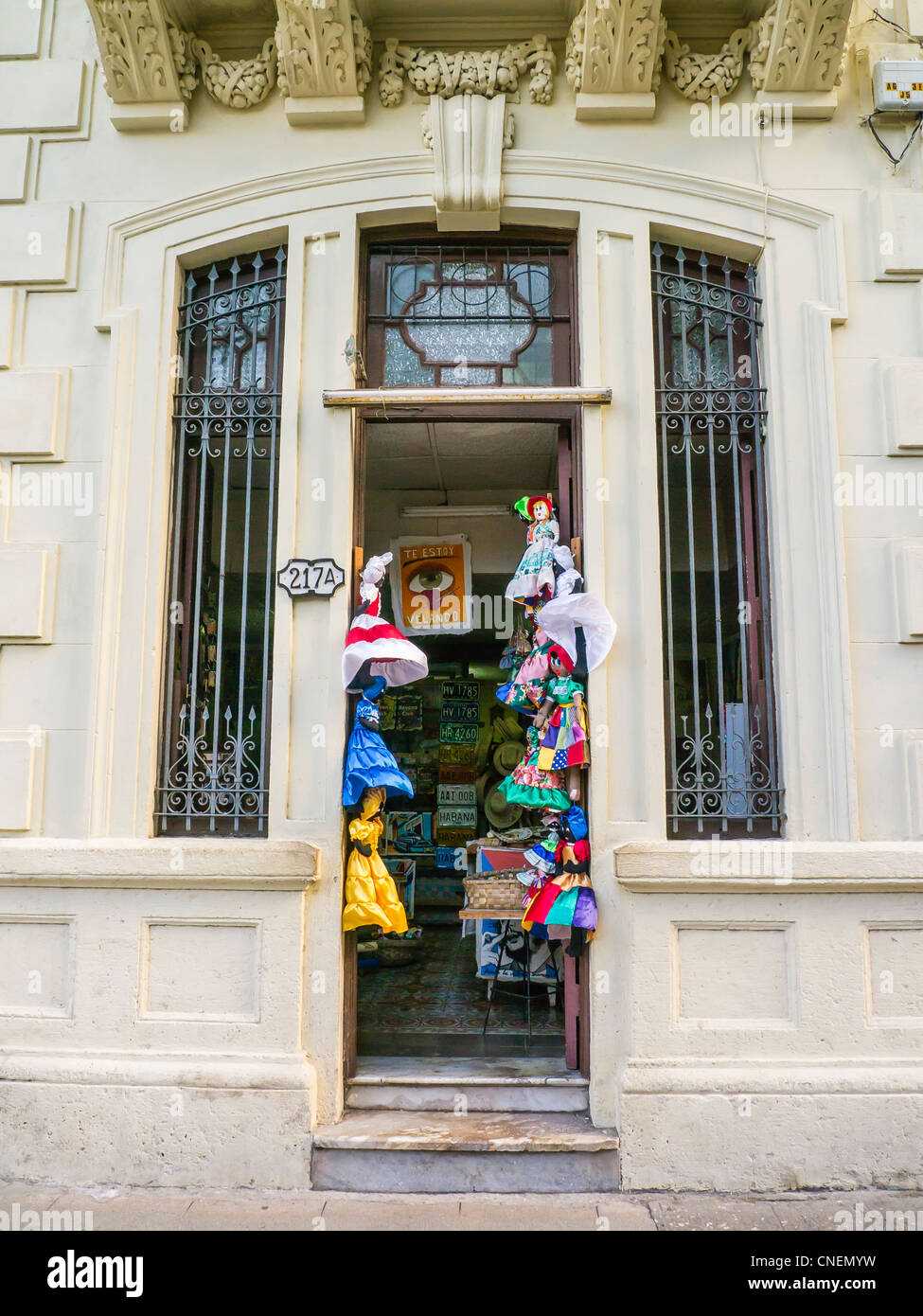 Abbigliamento per bambini si blocca su entrambi i lati della porta di ingresso di un negozio di l'Avana, Cuba. Foto Stock
