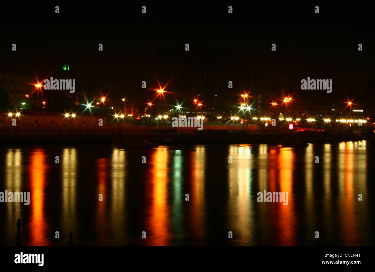 Città di notte con le luci riflesse in acqua Foto Stock