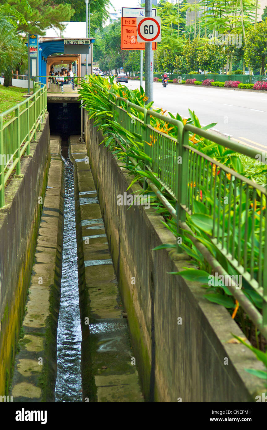 Aprire la pioggia delle acque reflue di fognatura sotto la fermata del bus di central Singapore Foto Stock