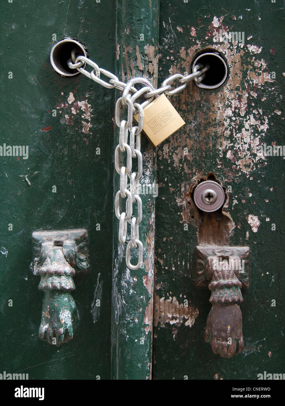 Vecchia casa verde porta bloccata con catena e lucchetto Foto Stock