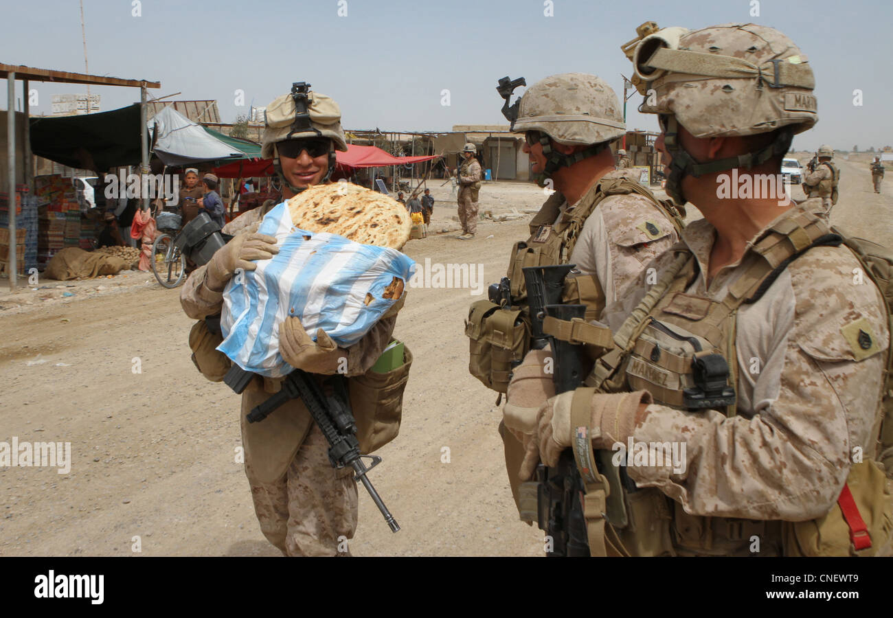 CPL. Marino USA Ricardo Figueroa, un Temecula, California, nativo ed elettricista che serve con il Regimental Combat Team 5, volontari per portare il pane acquistato in un bazaar qui, 6 aprile 2012. Colonnello Roger Turner e Sgt. Alberto Ruiz, il comandante e sergente maggiore RCT-5, ha visitato i Marines e le forze di sicurezza nazionali afghane in diversi avamposti di combattimento in tutto il distretto di Marjah, nella provincia di Helmand. Foto Stock