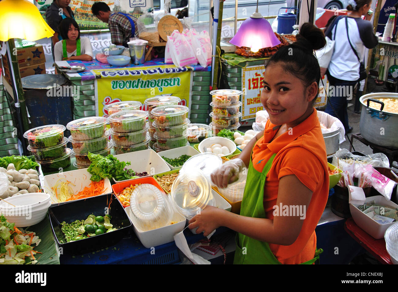Giovane donna fare insalate in cucina di strada in stallo, New Phetchaburi Road, Ratchathewi District, Bangkok, Thailandia Foto Stock
