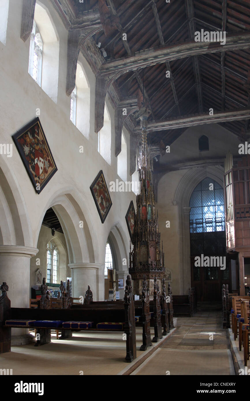 La navata della chiesa Ufford con il famoso del xv secolo coperchio font nel centro. Foto Stock