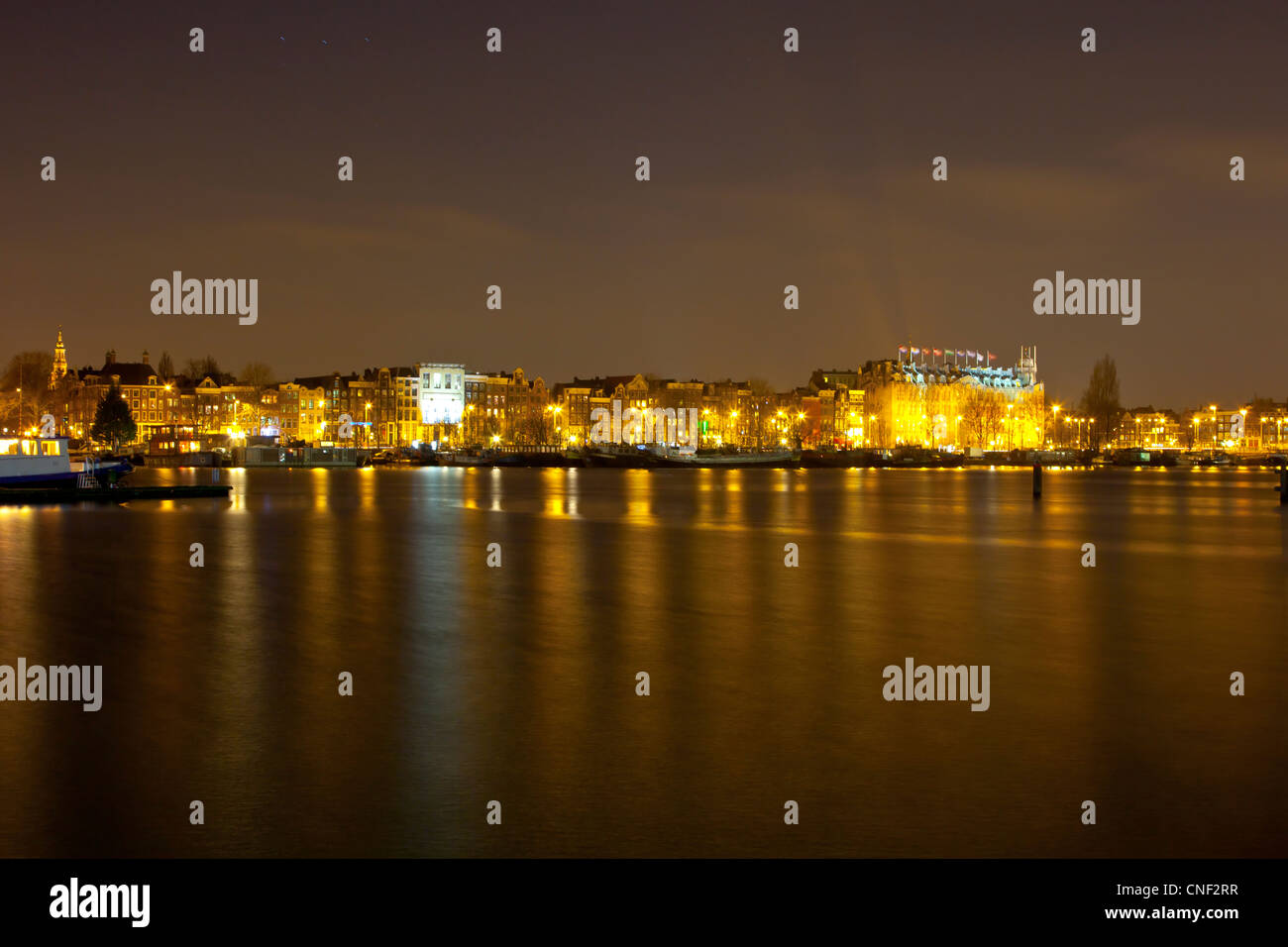 Amsterdam skyline notturno con edifici storici e barche Foto Stock