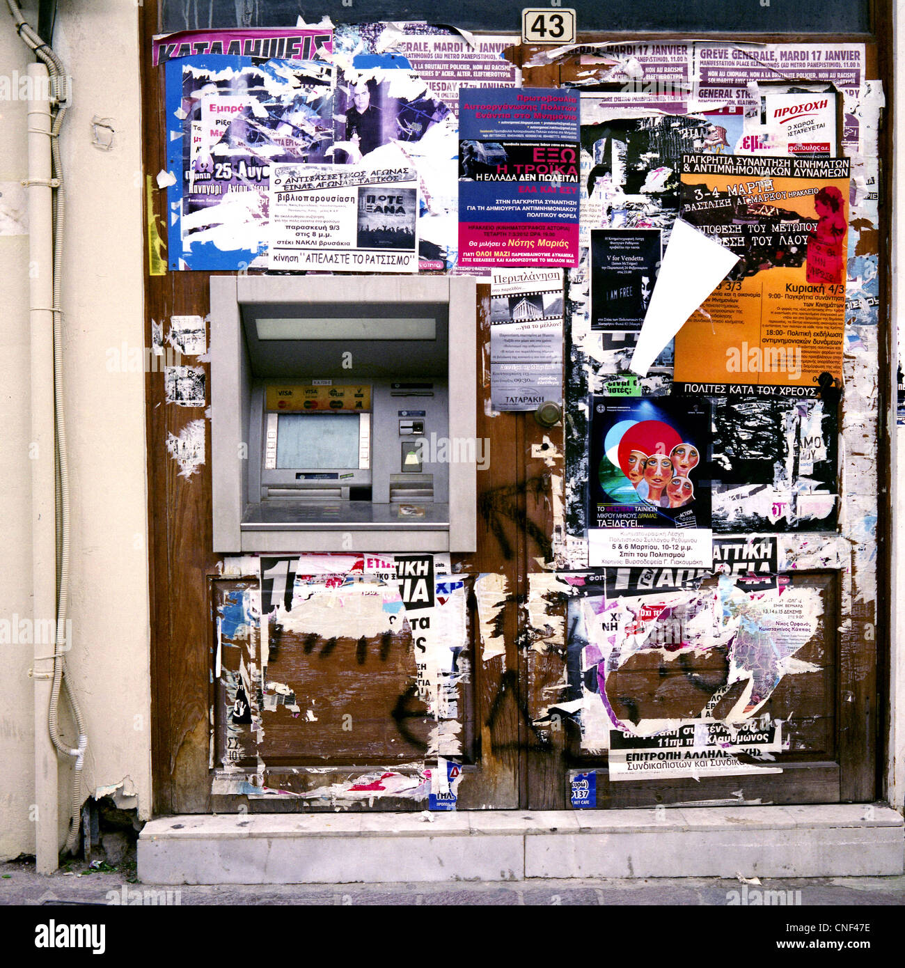 Una banca greca di tesoreria della macchina nella parete di un negozio abbandonato a Rethymnon, Creta, Foto Stock