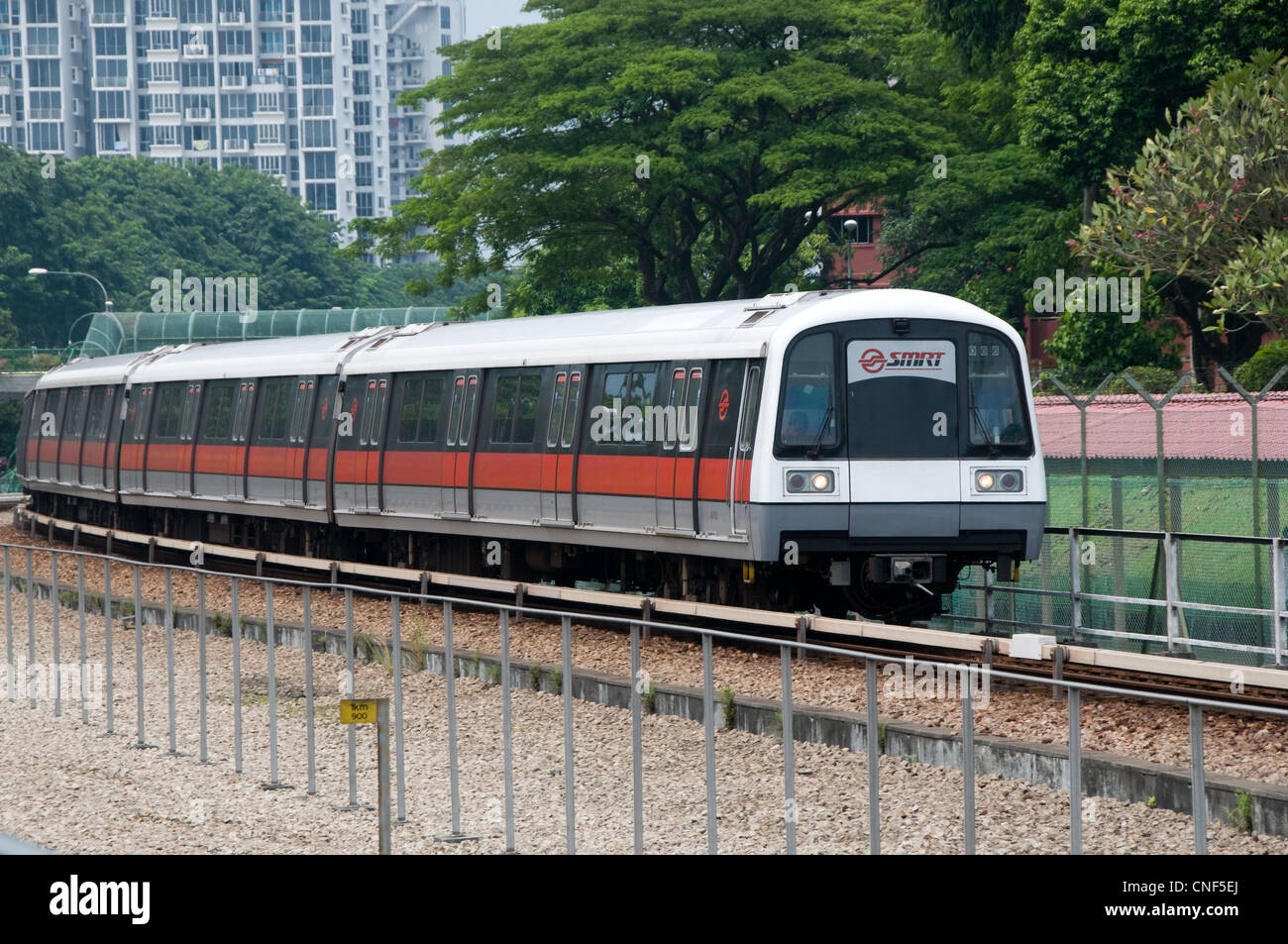 Un treno della metropolitana azionato da SMRT si avvicina ad una stazione su una sezione aperta della linea Foto Stock