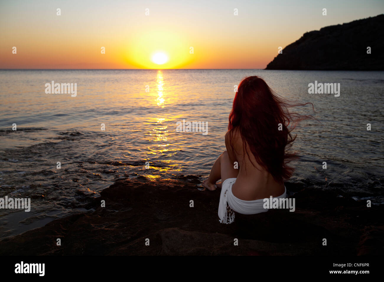 Giovane e bella donna nuda guardando alba sulla spiaggia di Rodi. Mattina  greca Foto stock - Alamy