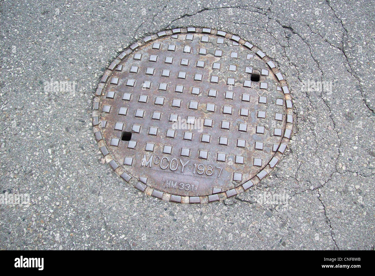 I tombini sono componenti essenziali delle infrastrutture urbane e forniscono un accesso sicuro alle utenze sotterranee come acqua, gas ed elettricità. Realizzati in materiali resistenti, garantiscono sicurezza e funzionalità negli spazi pubblici. Foto Stock