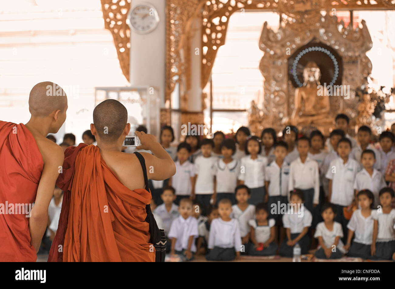 La Pagoda Kuthodaw, Mandalay Birmania. Myanmar. Un gruppo di scolari fotografata da monaci Foto Stock
