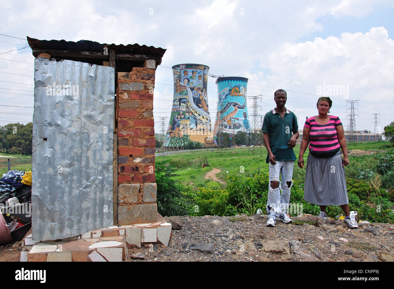 Coppia in Township mostrando servizi igienici esterni e Orlando Cooling Towers, Soweto, Johannesburg, Provincia di Gauteng, Repubblica del Sud Africa Foto Stock