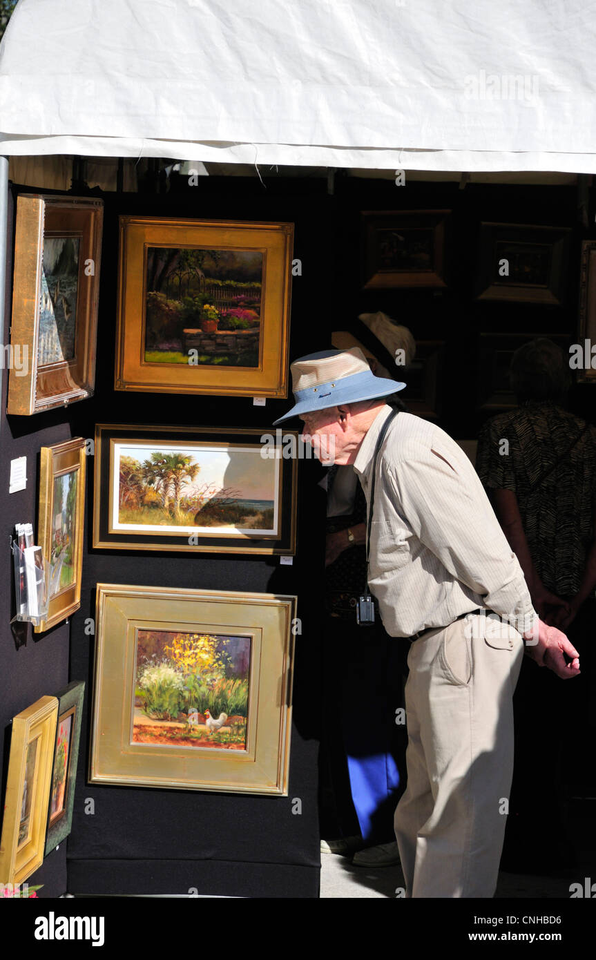 L'uomo checking out dipinti al 2012 Festival delle Arti di New Smyrna Beach, Florida Foto Stock