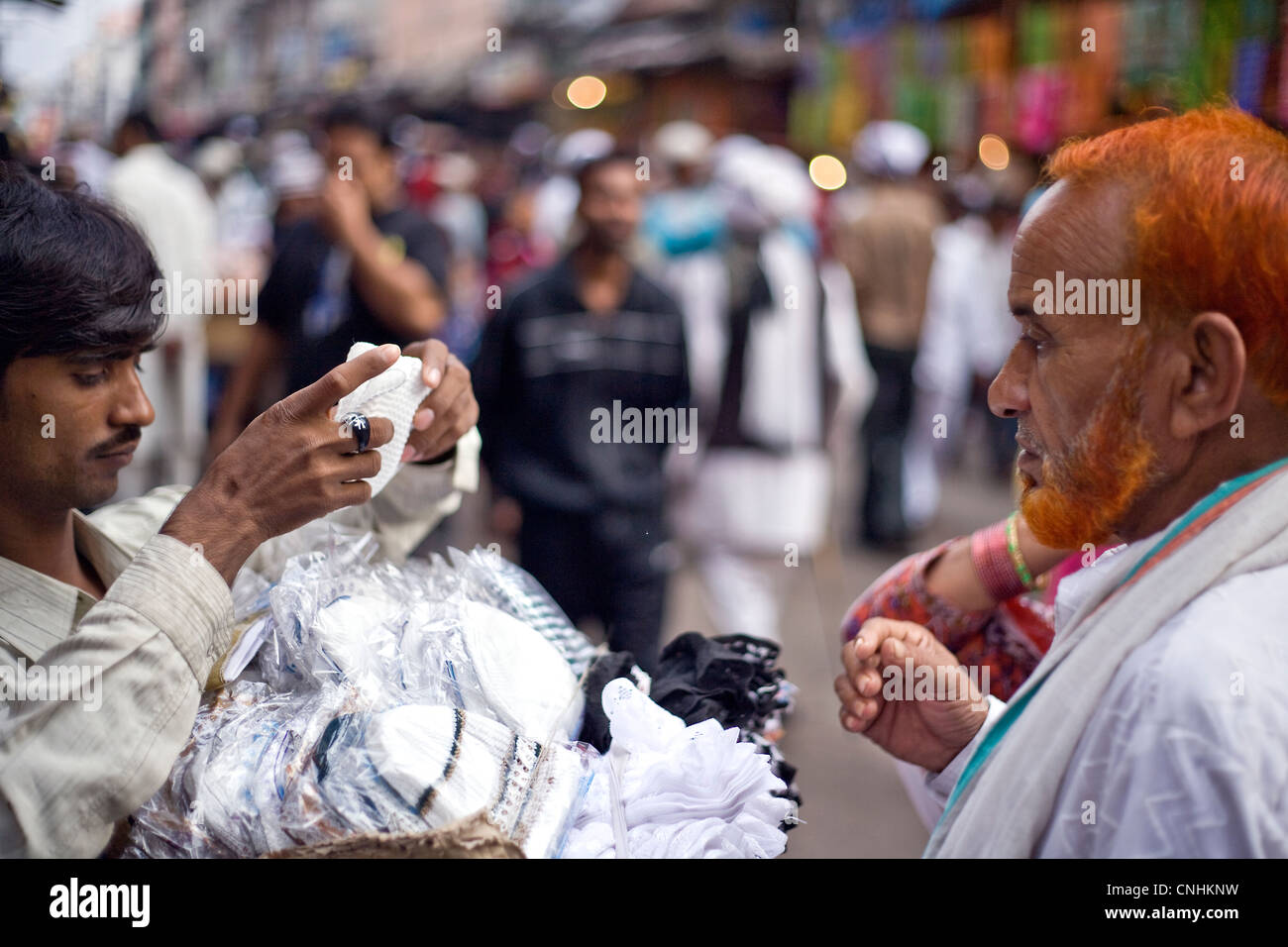 Pellegrino musulmano cappuccio di acquisto di fronte al santuario di Ajmer Foto Stock