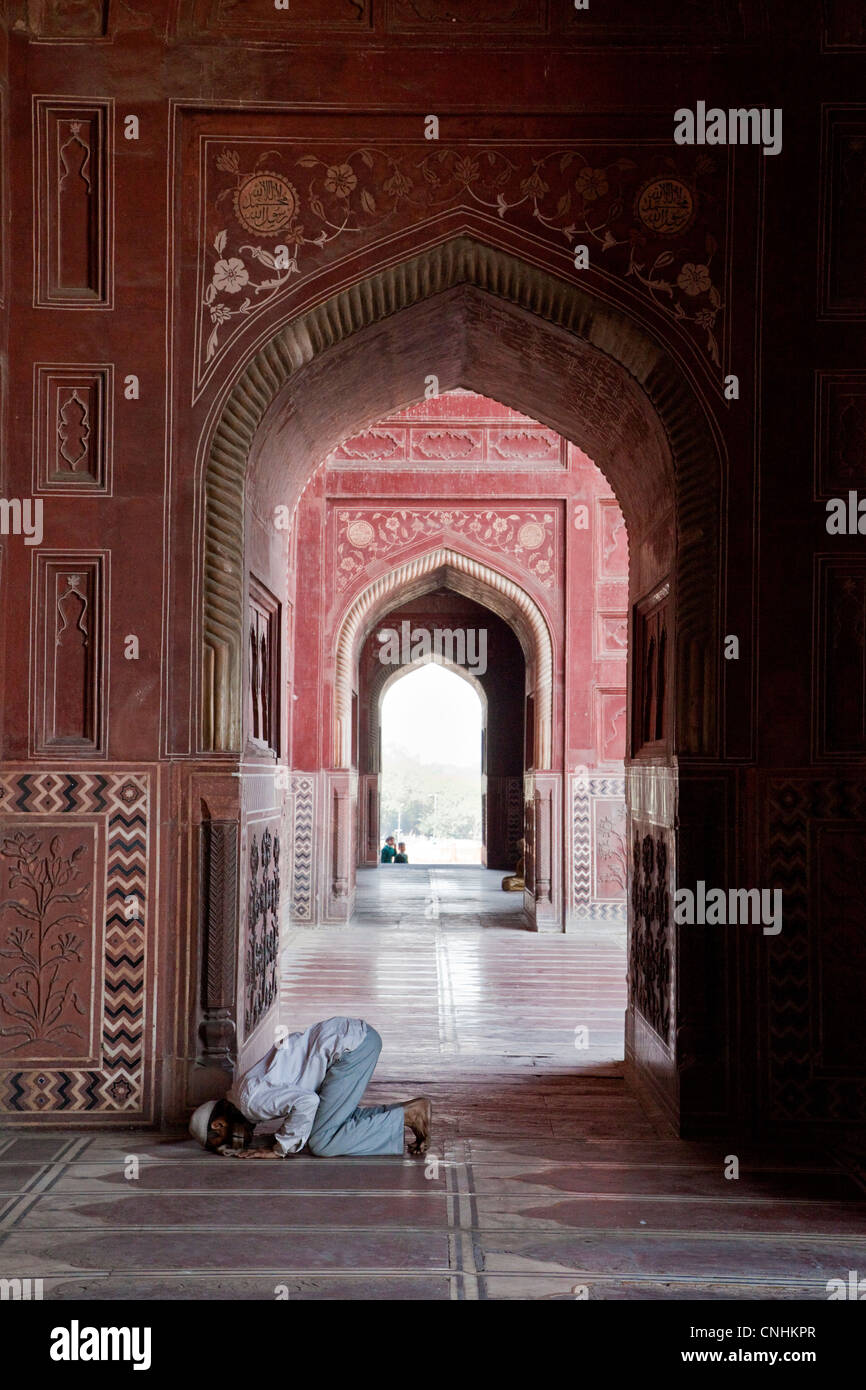 Agra, India. Taj Mahal moschea. Uomo che prega. Foto Stock