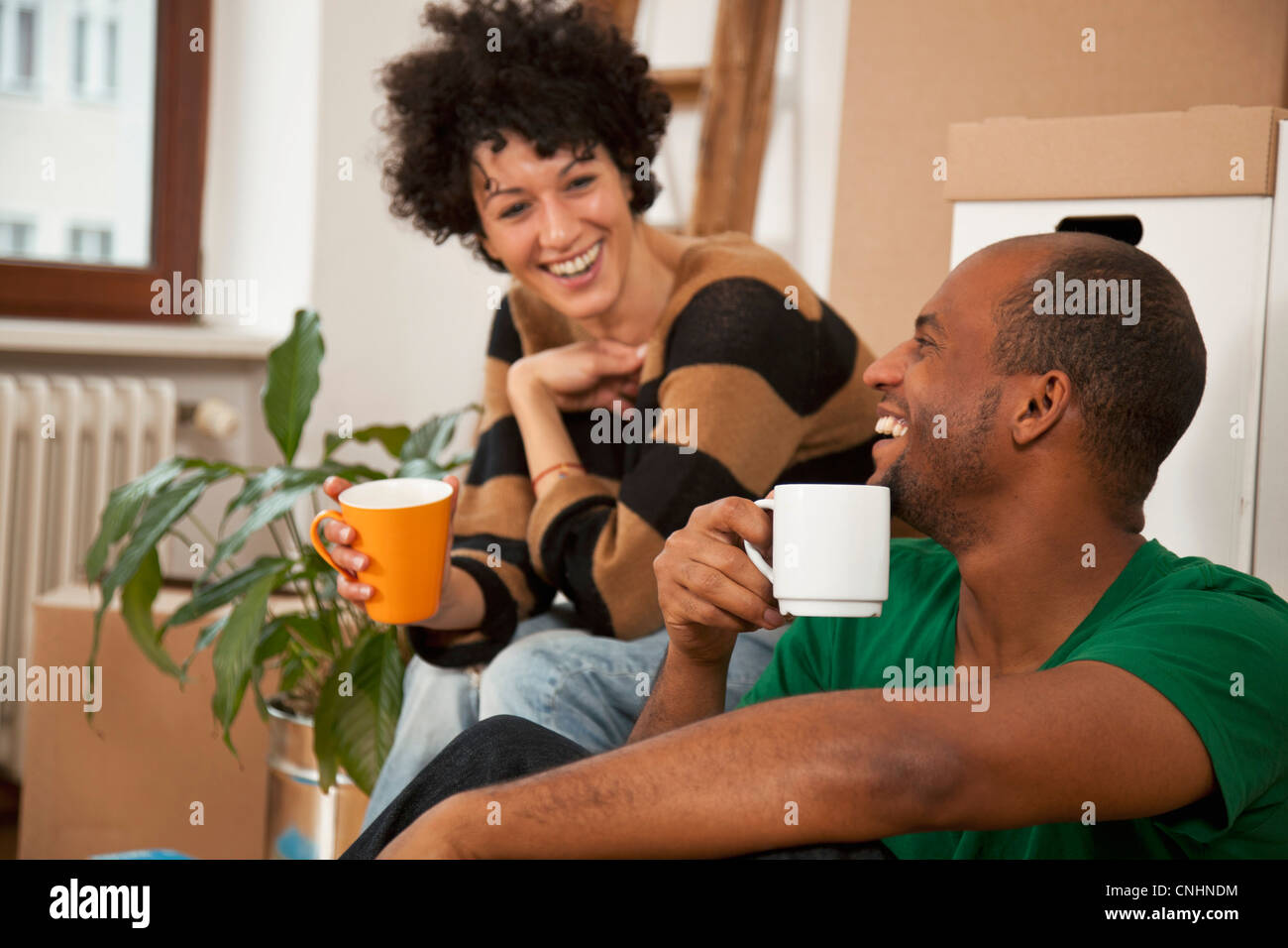 Una ridente giovane prendendo una pausa caffè mentre il trasloco, close-up Foto Stock