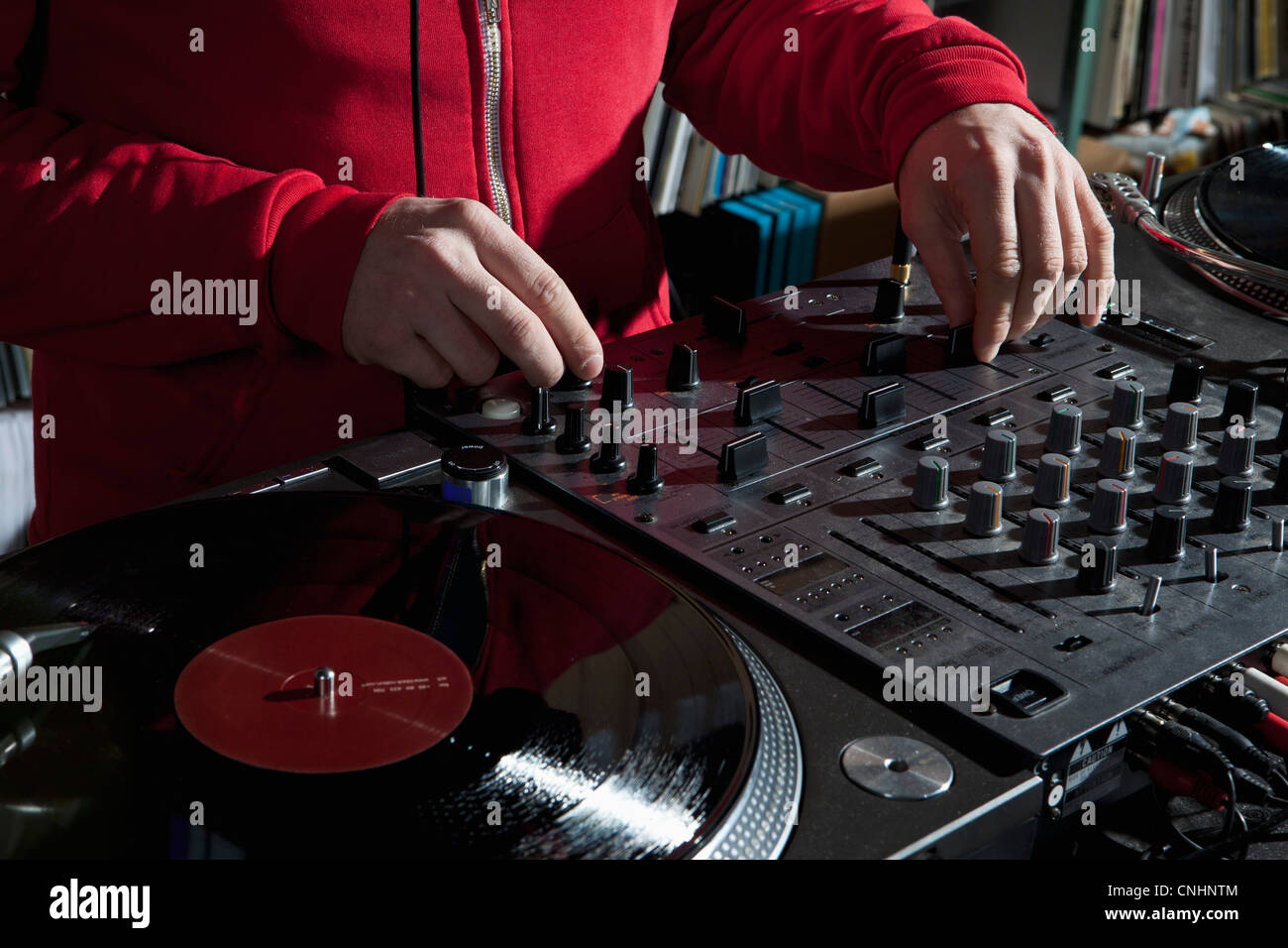 Un DJ manopole di regolazione su un ecoscandaglio miscelatore, dettaglio delle mani Foto Stock