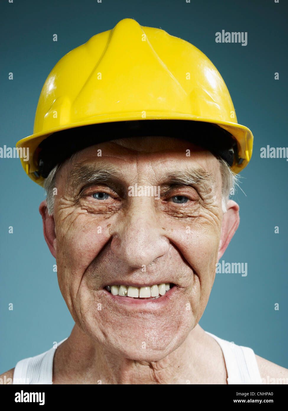 Colpo di testa di un uomo anziano che indossa un casco giallo Foto Stock