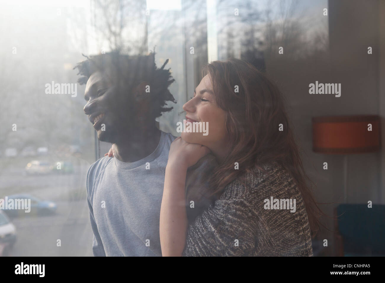 Un affettuoso giovane guardando fuori della finestra Foto Stock