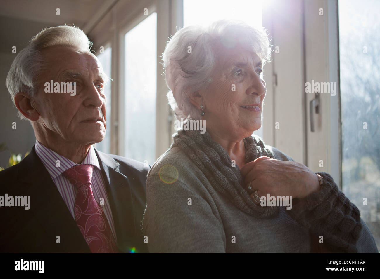 Una coppia senior guardando fuori della finestra a vista Foto Stock