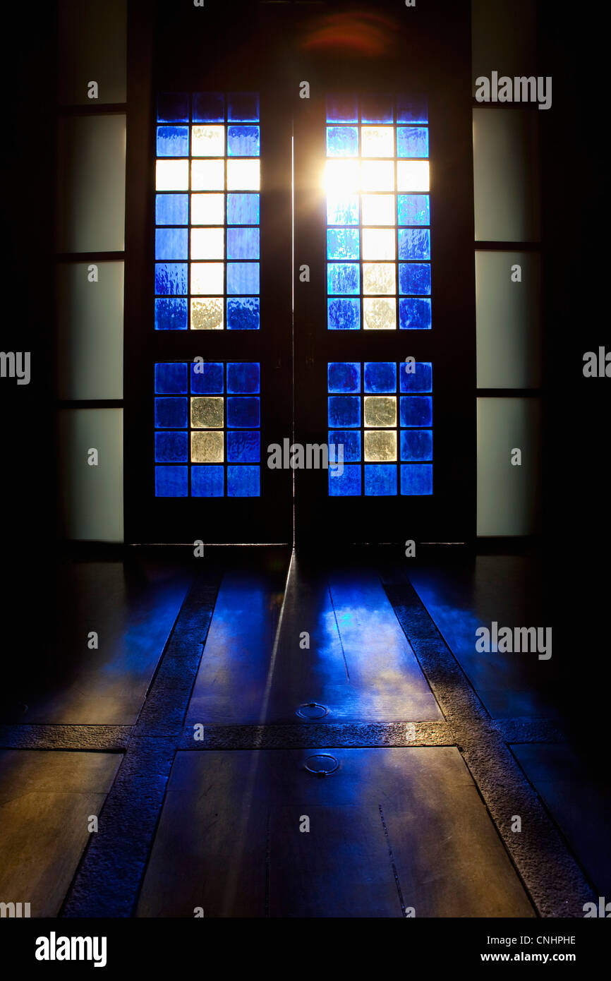 Colore blu proiettata sul piano attraverso la porta a vetri colorati Foto Stock