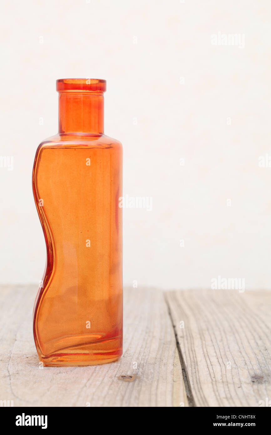 Vecchia bottiglia di vetro sul tavolo di legno Foto Stock