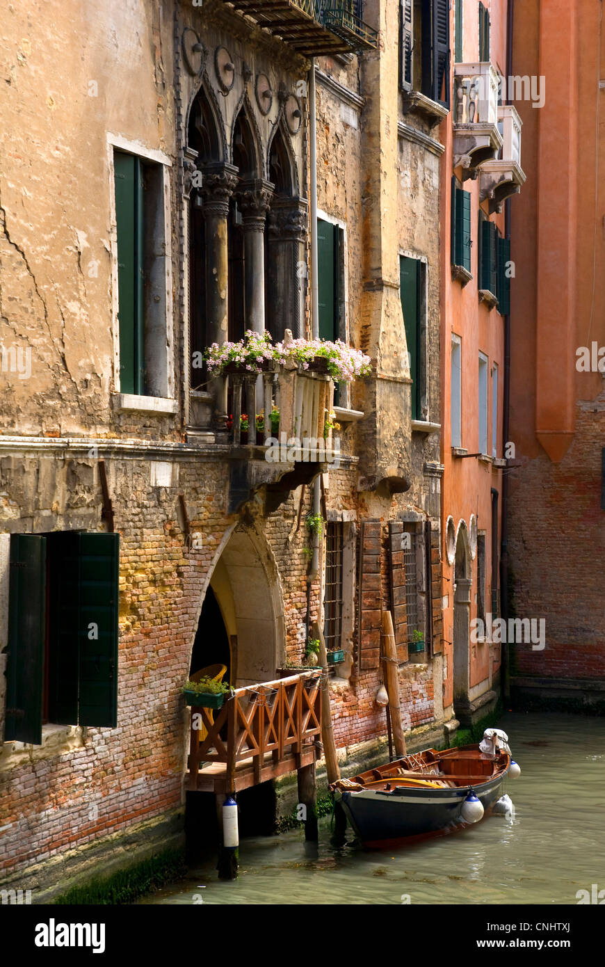 Canale veneziano con piccola imbarcazione per la porta anteriore, Venezia Foto Stock