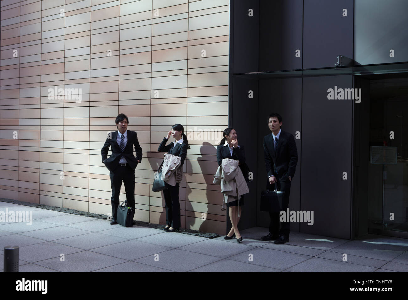 I datori di lavoro al di fuori di un edificio per uffici a Tokyo Foto Stock