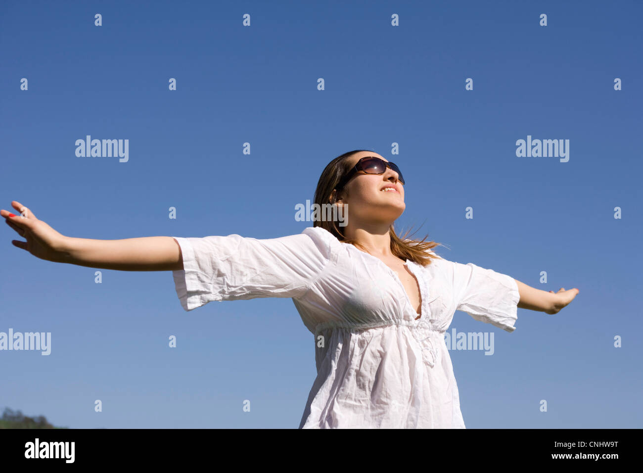 Giovane donna con le braccia fuori teso per godersi il sole. Foto Stock