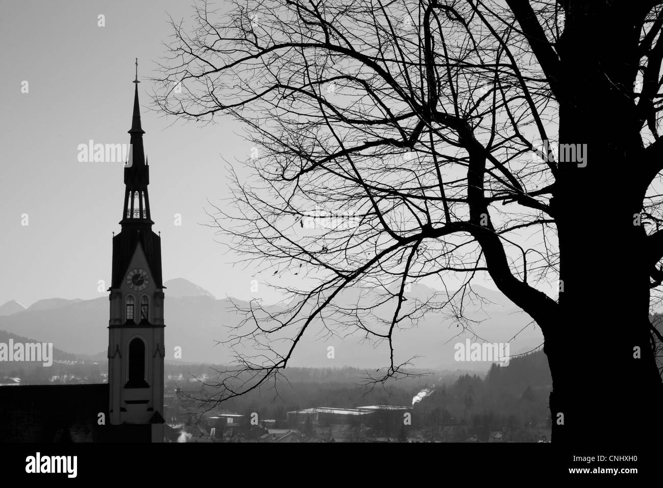 Bianco e nero immagine silhouette di una chiesa campanaria e albero in Bad Tölz, Baviera, Germania. Foto Stock