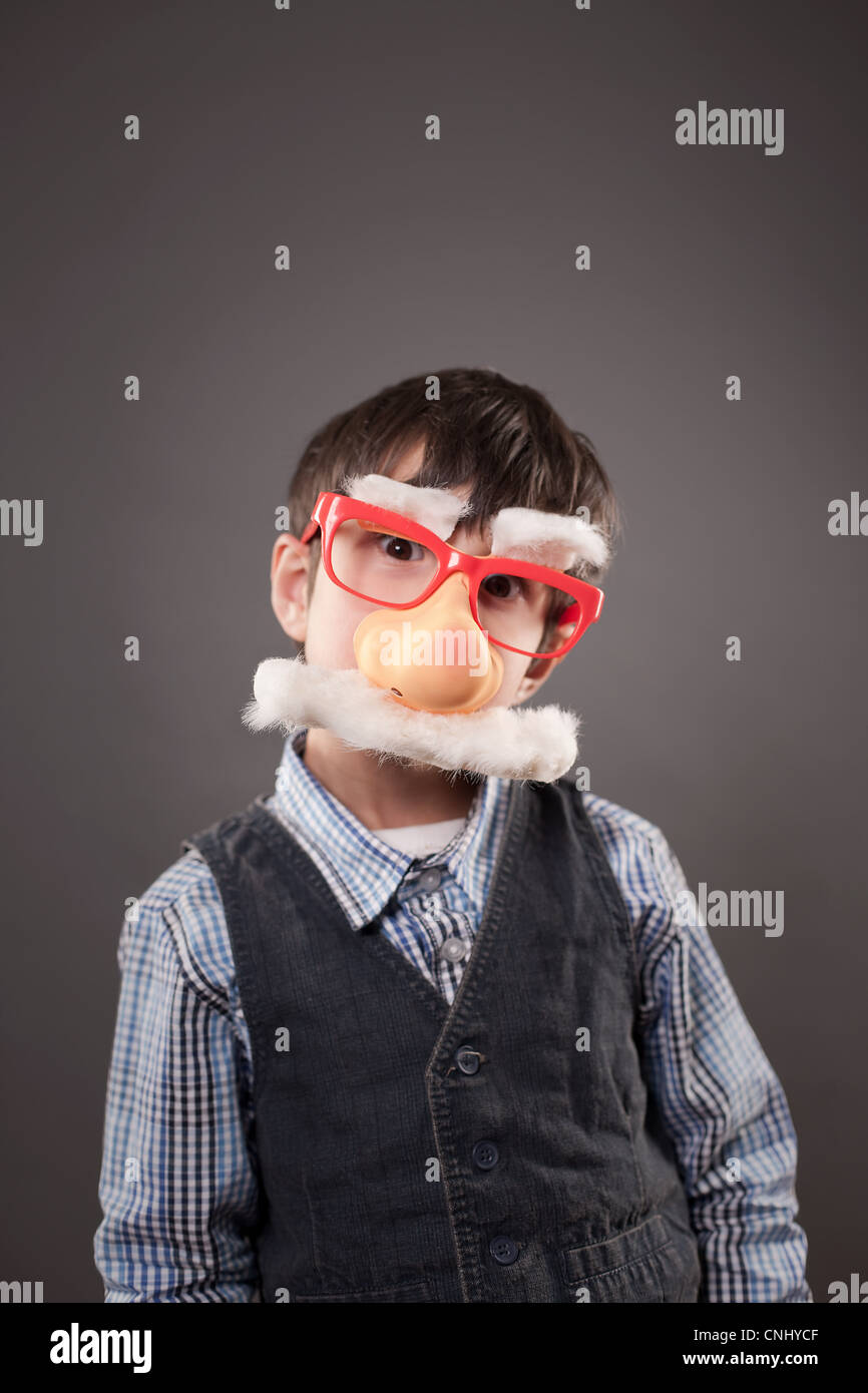 Ragazzo che indossa un divertente faccia travestimento Foto Stock