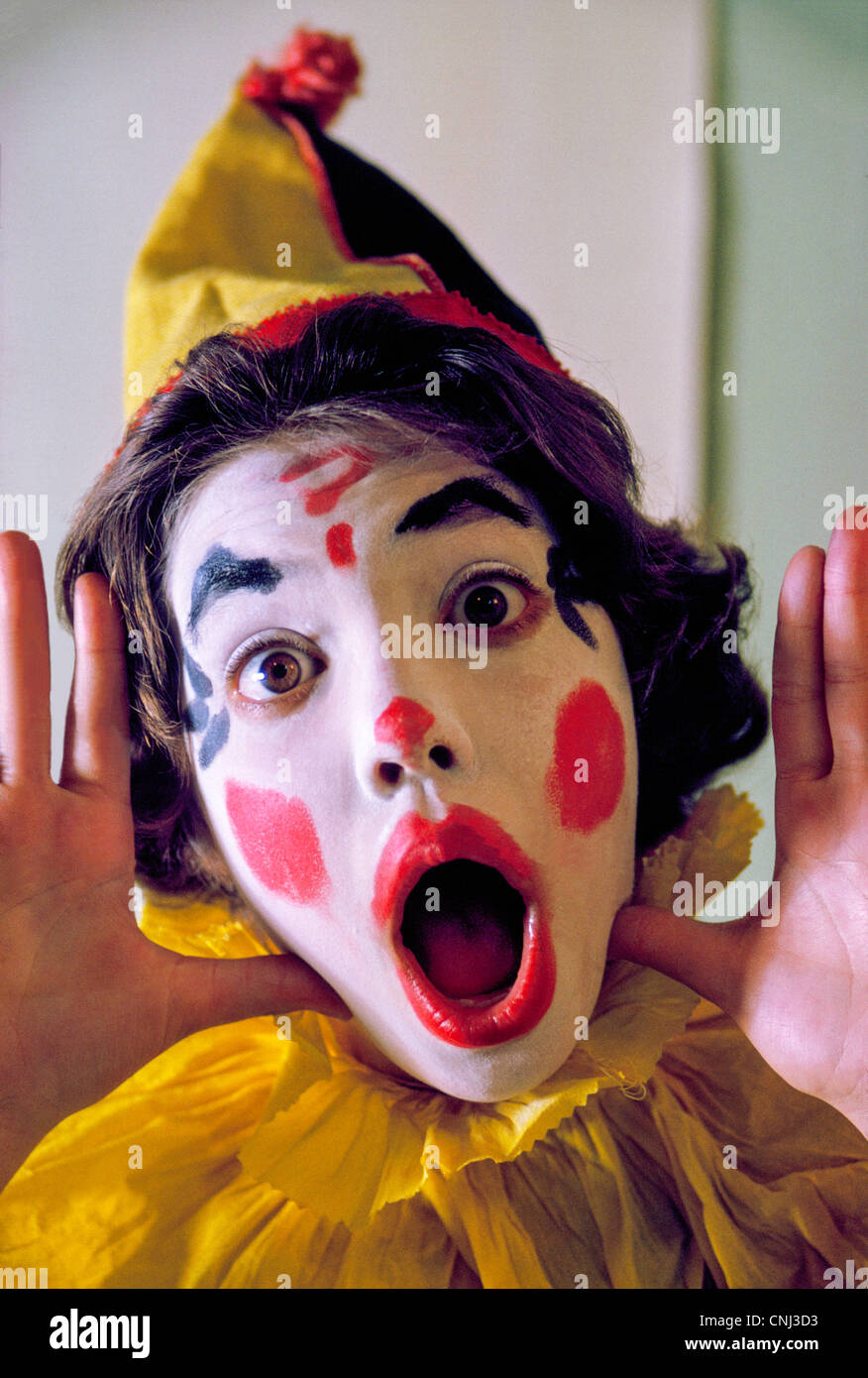Una giovane ragazza abiti fino come un colorato circus clown per andare ingann-o-trattare durante l'annuale festa di Halloween negli Stati Uniti nel mese di ottobre 31st. Foto Stock
