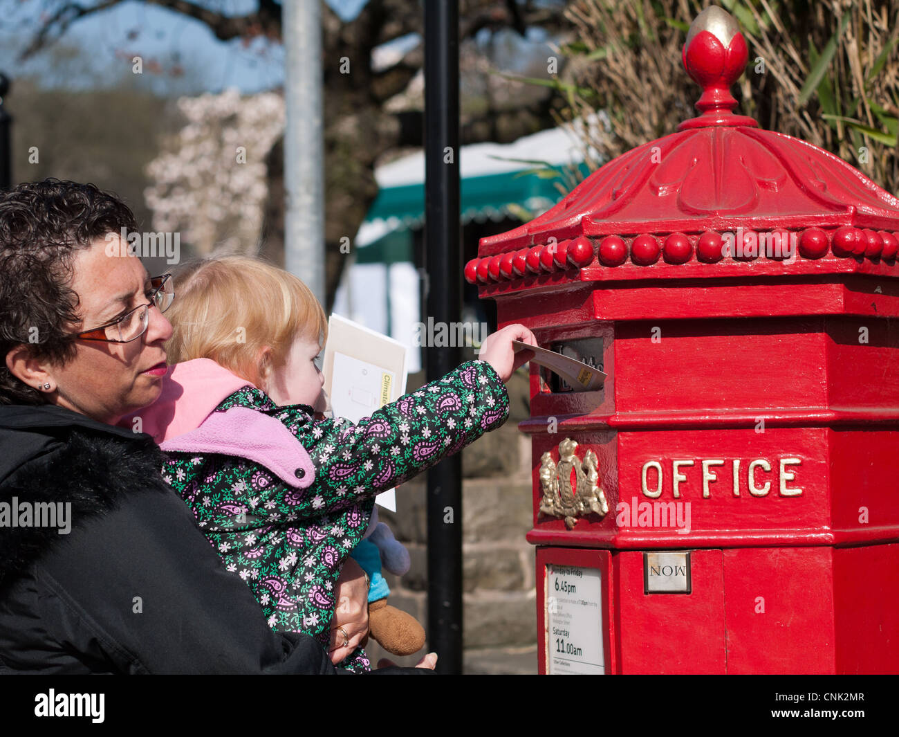 Madre e figlia invio di lettere in tradizionale cassetta postale Foto Stock