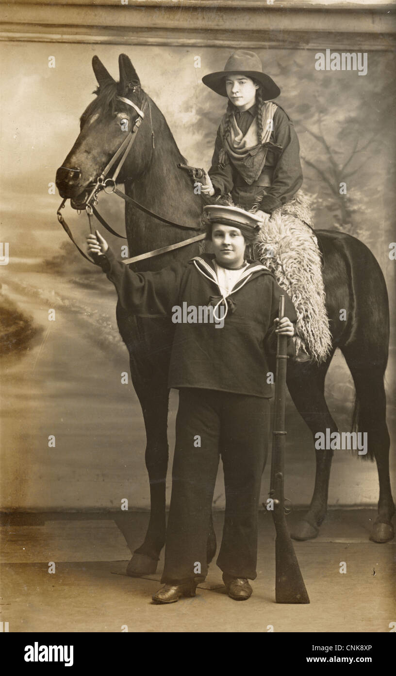 Due ragazze in costume con cavallo finto Foto Stock