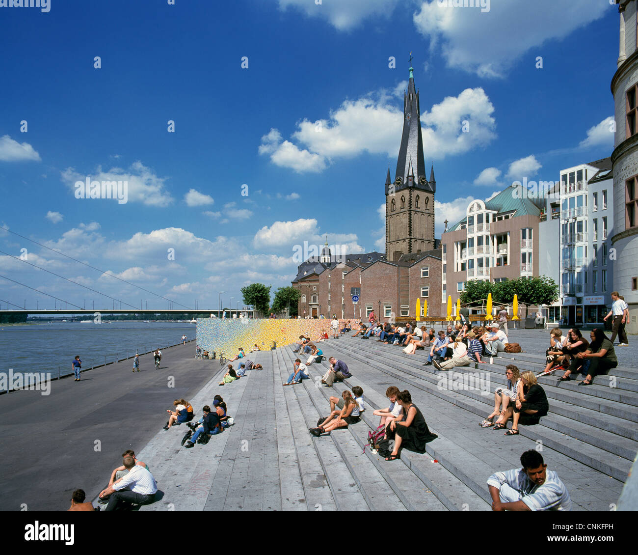 Rheinuferpromenade, Menschen sitzen auf der Spanischen Treppe am Rheinufer, dahinter die Kirche St. Lambertus und die Oberkasseler Rheinbruecke, Duess Foto Stock